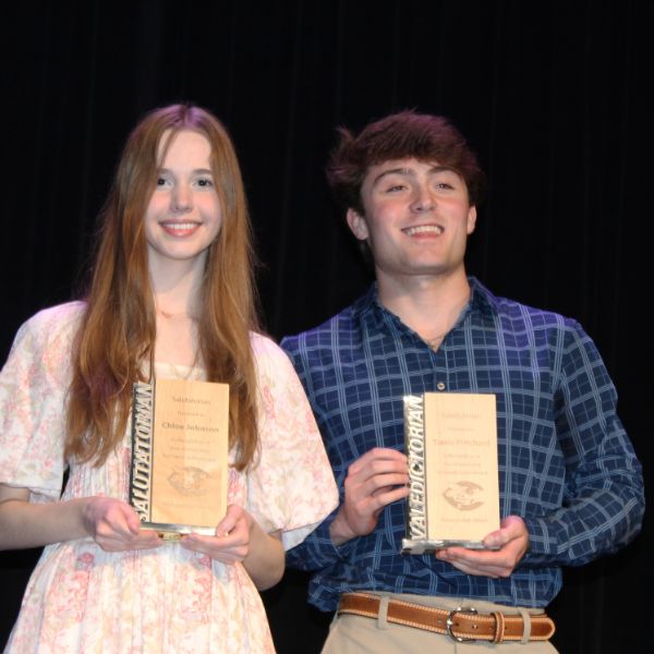  girl and boy holding awards